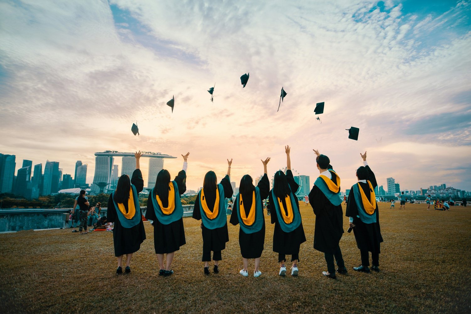 Studenti in toga che lanciano il tocco al cielo